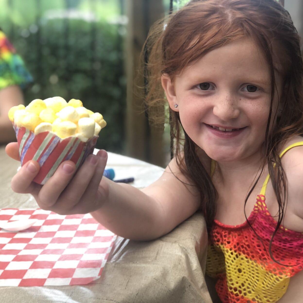 Girl decorates cupcake at Let's Get Crafty! event